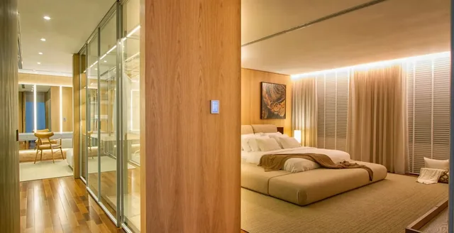 Suíte com iluminação cênica e teclado Piero na coluna de madeira ao lado do closet